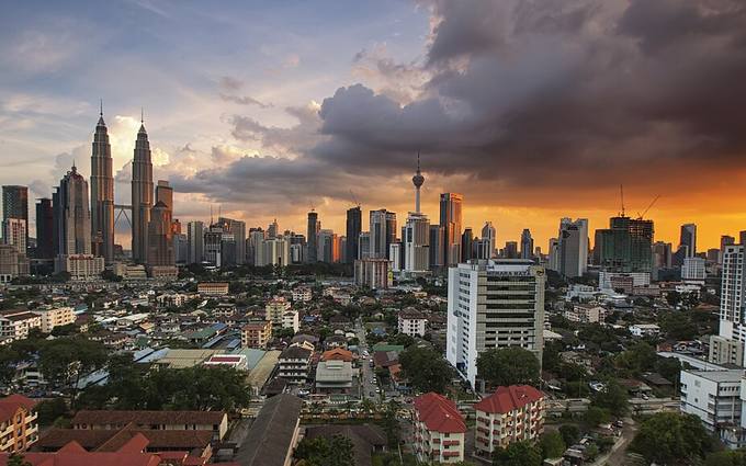 Kuala Lumpur skyline at dusk with the Petronas Towers and KL Tower.